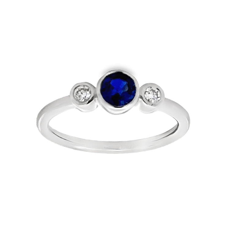 14Kt White Gold Bezel-set, 3 Stone Ring with .48Ct Round Blue Sapphire Center stone and .10tw Diamond side stones. Stock size 6.25 can be sized to order.  Dimensions;&nbsp; 5.42mm diameter top, 1.8mm shank, 4.11mm high from top of finger.