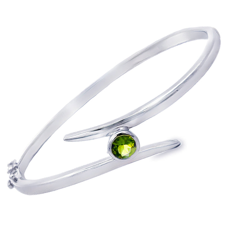 Sterling Silver Hinged Bangle Bracelet with bezel set genuine Peridot in a bypass design. Fastens with a pressure clasp and supplemental safety-8.&amp;nbsp;