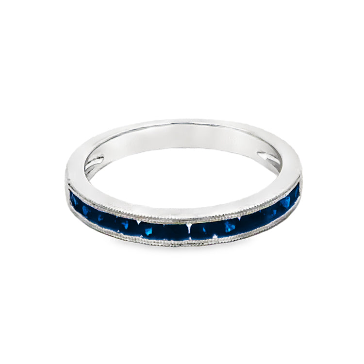 14Kt white gold, stackable band style ring with .55tw channel-set, round blue sapphires and accented with milgrain detail. Stock size 6.5 can be sized to order.  Dimensions; 2.8mm wide, 2.3mm high from top of finger.