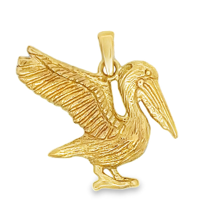 14Kt Yellow Gold Pelican Pendant. This stunning statement piece captures the majestic bird's beauty in intricate detail. Ready to take flight and add a touch of beachy charm to any outfit. Dimensions; 7/8" drop, 1" wide, open back