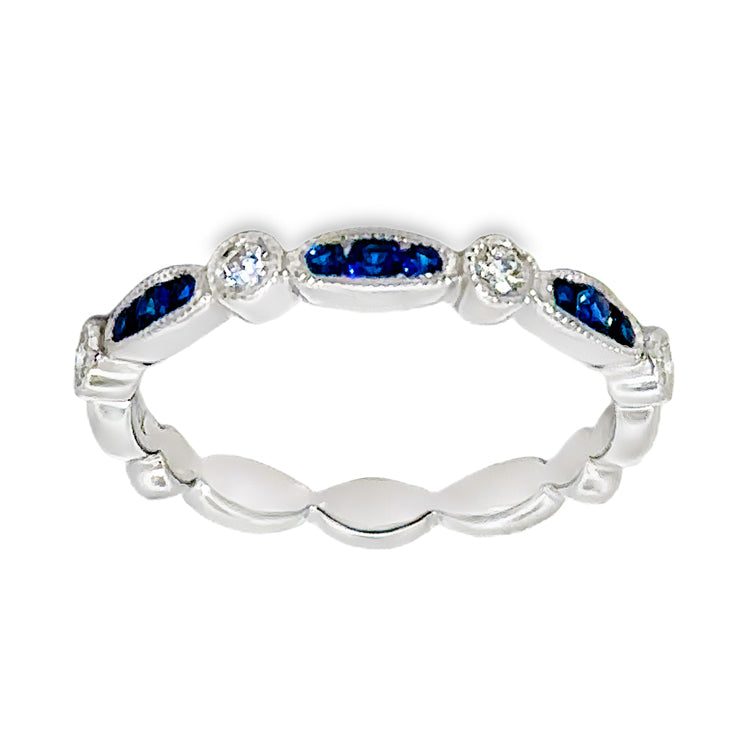 14Kt white gold, stackable band style ring with alternating navette and round sections that are accented with milgrain detail. The three ceter navette shapes are set with .17tw Round Blue Sapphires alternating with four round sections set with .17tw round diamonds. Stock size 6.25 can be sized to order.  Dimensions; 2.79mm wide top, 2.73mm shank, 2.4mm high from top of finger.