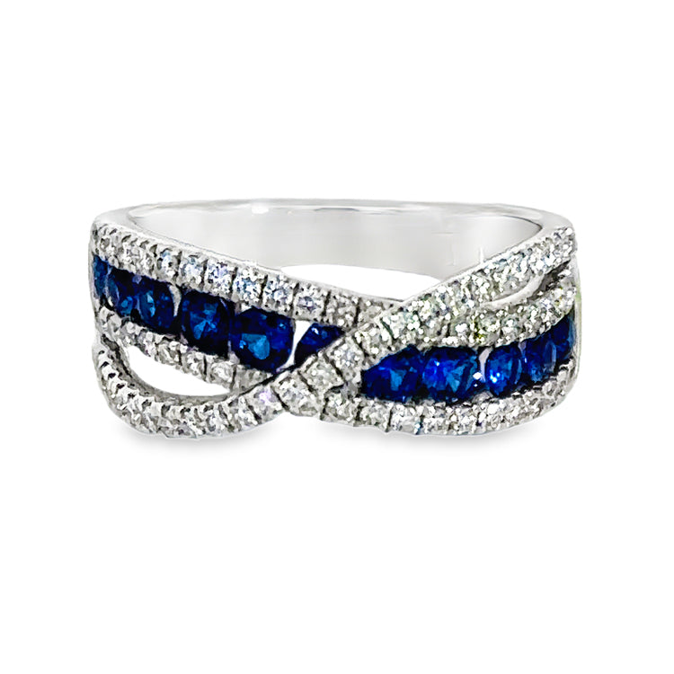 18Kt white gold curved band style ring with a row of .76tw round Blue Sapphires between two rows of Diamonds, with a raised crossover band of diamonds. Total diamond weight is .50tw. Stock size 6.5 can be sized to order.  Dimensions; 7.85mm wide at top, tapering to 3.24mm wide at base of shank. Top of ring is 4.42mm from top of finger.