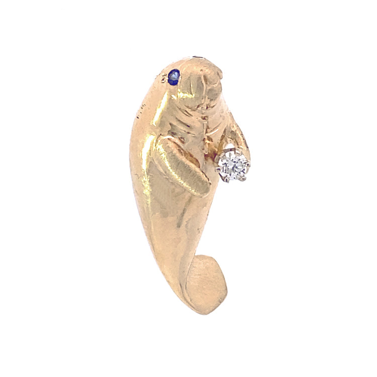 yellow gold upright manatee pendant with a diamond in its flipper. 