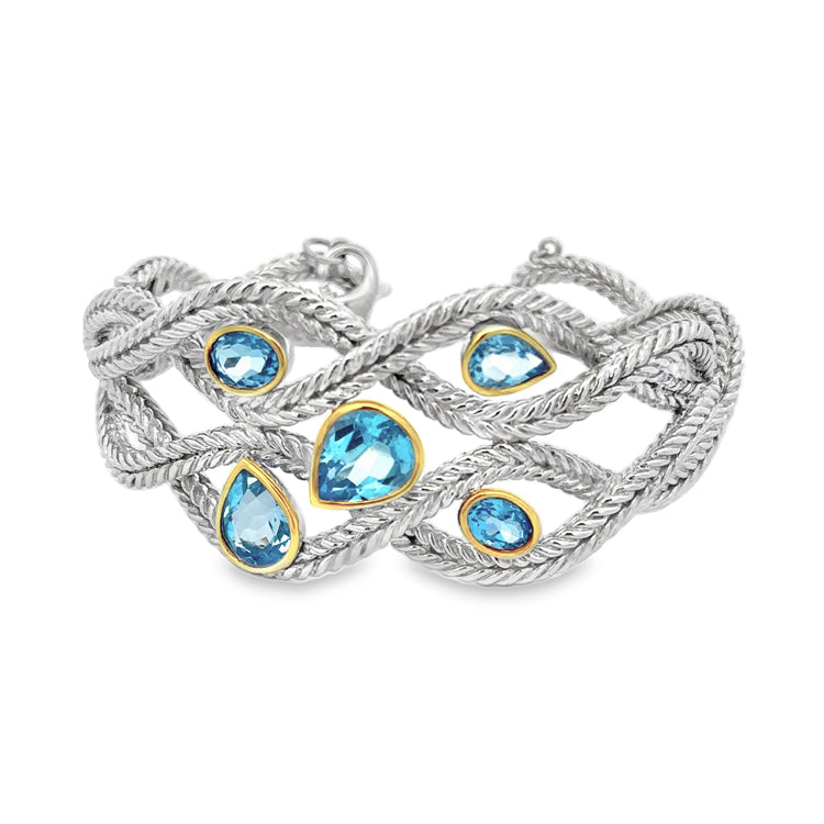 Sterling Silver open weave design cuff bracelet with Oval and Pear shape Blue Topaz in 14Kt yellow gold bezels. Solid craftsmanship with a hinge on one side for easy on and off. Safety chain with lobster clasp.