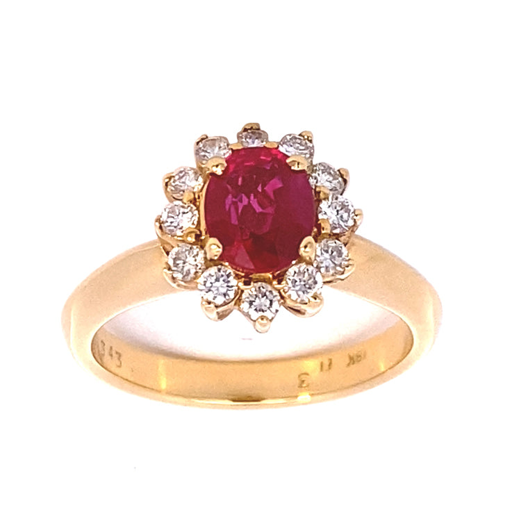 Estate 18Kt yellow gold ring with twelve full cut round brilliant diamonds surrounding a faceted oval Ruby weighing approximately 1.20ct. The twelve full-cut, round brilliant diamonds have an estimated total weight of .33tw.